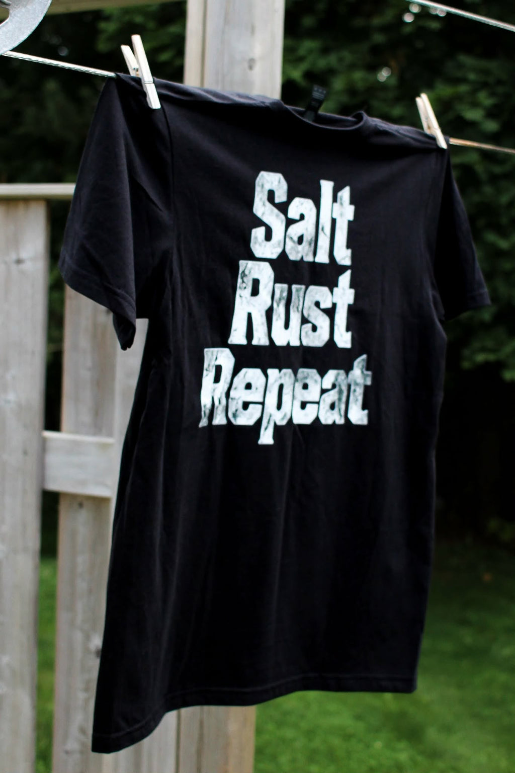 Black t-shirt with Salt Rust Repeat text on the back